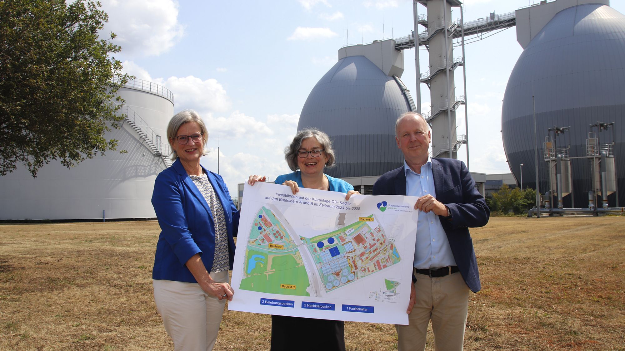 Kirsten Bollrich (Leiterin Ausbau Kläranlage), Eva Jähnigen (Umweltbürgermeisterin Landeshauptstadt Dresden) und Ralf Strothteicher (Technischer Geschäftsführer der Stadtentwässerung) präsentieren die Ausbaupläne bis 2038, im Hintergrund die Faultürme im Klärwerk Dresden-Kaditz - Foto: J. Frintert