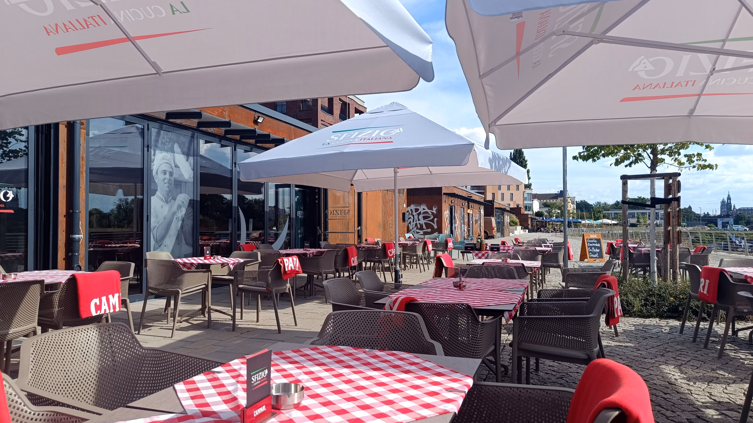 Luftige Atmosphäre im „Sfizio“ am Hafen: Die Glasfassade lässt sich bei gutem Wetter öffnen und sorgt für echtes Open-Air-Feeling.