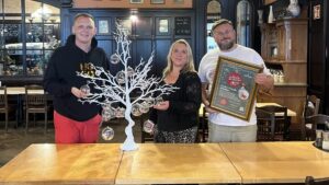 Vorfreude aufs Adventssingen: Vertreter von Alberthafen, Watzke und der Arche präsentieren die Charity-Kugeln im Ball- und Brauhaus.