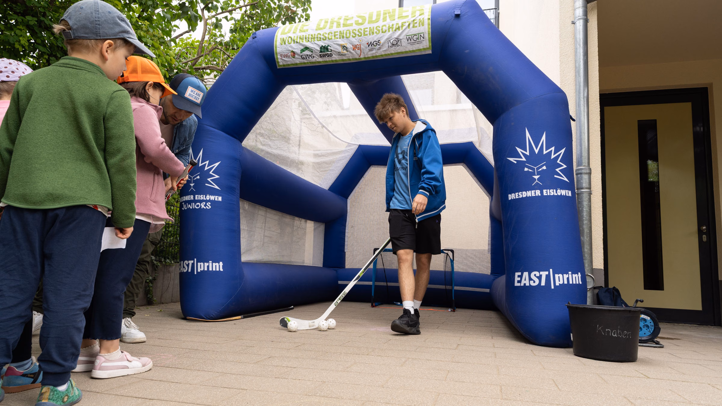 Die Eislöwen Robert Zimmermann und Lukas Hickmann zeigen den Kindern das Eishockey-Schießen. Foto: Sebastian Diehl